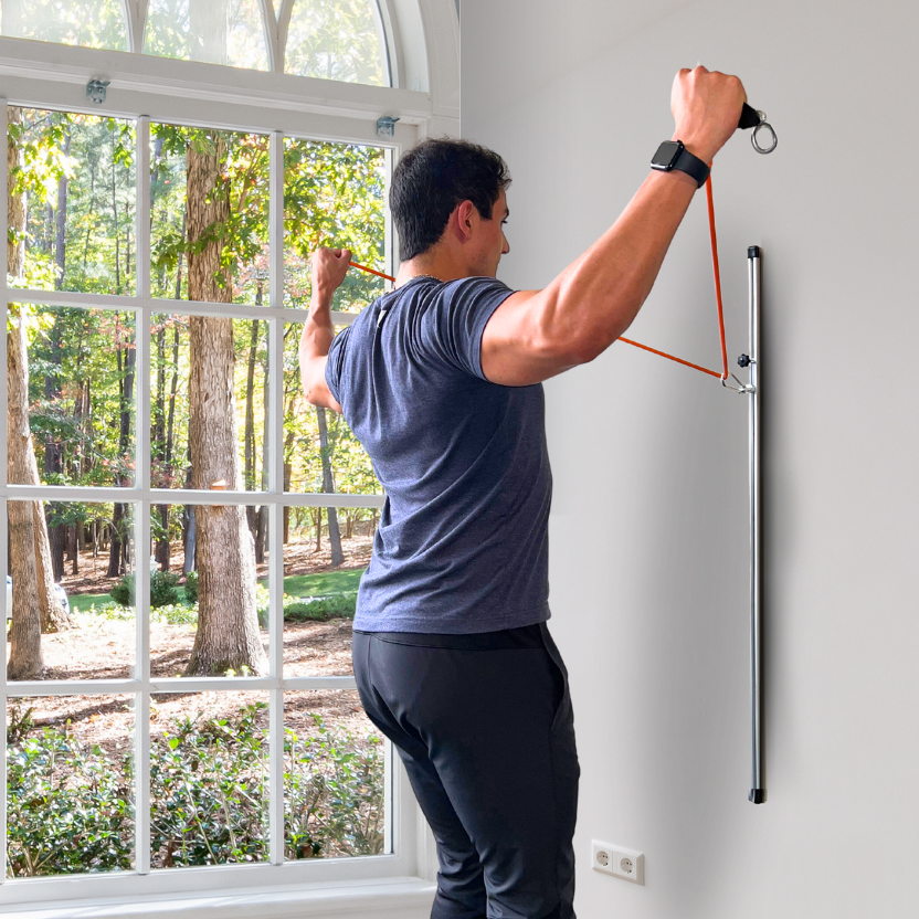 User is performing back exercise with resistance band wall mount.