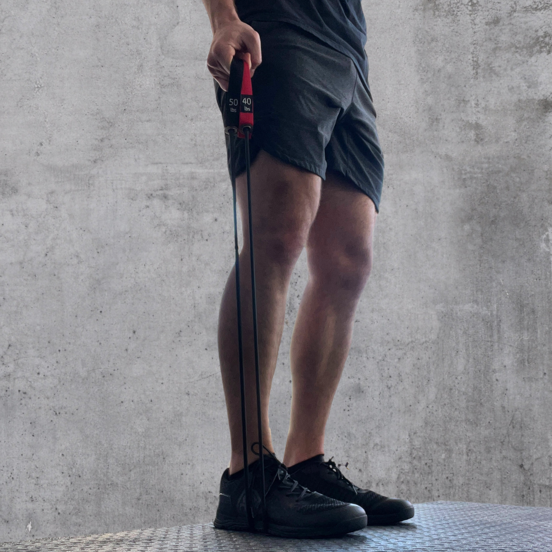 Man using resistance bands to perform exercises. The two exercise bands are in his right hand.